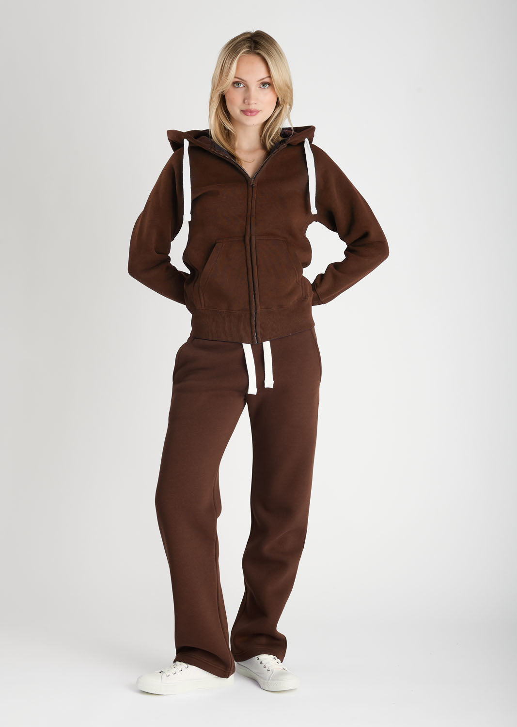 Woman wearing a brown tracksuit on a white background