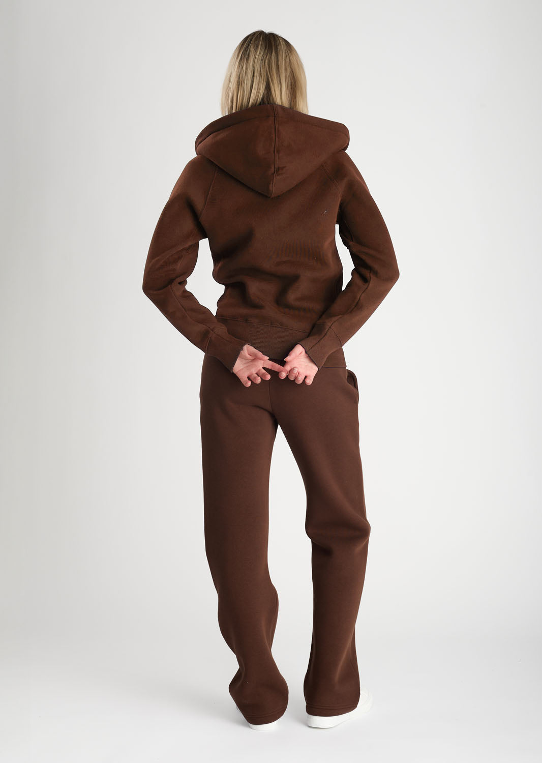 Person wearing a brown onesie against a white background
