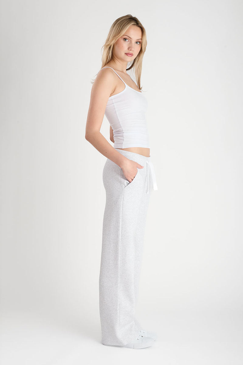 Woman wearing a light grey outfit on a plain background