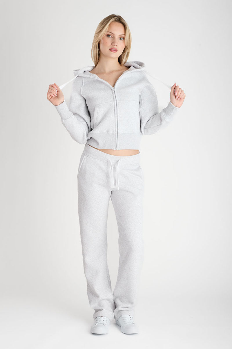 Woman wearing a gray tracksuit on a white background