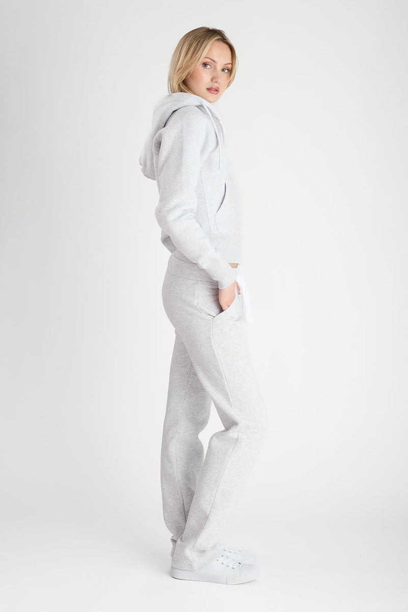 Person wearing a gray tracksuit on a white background