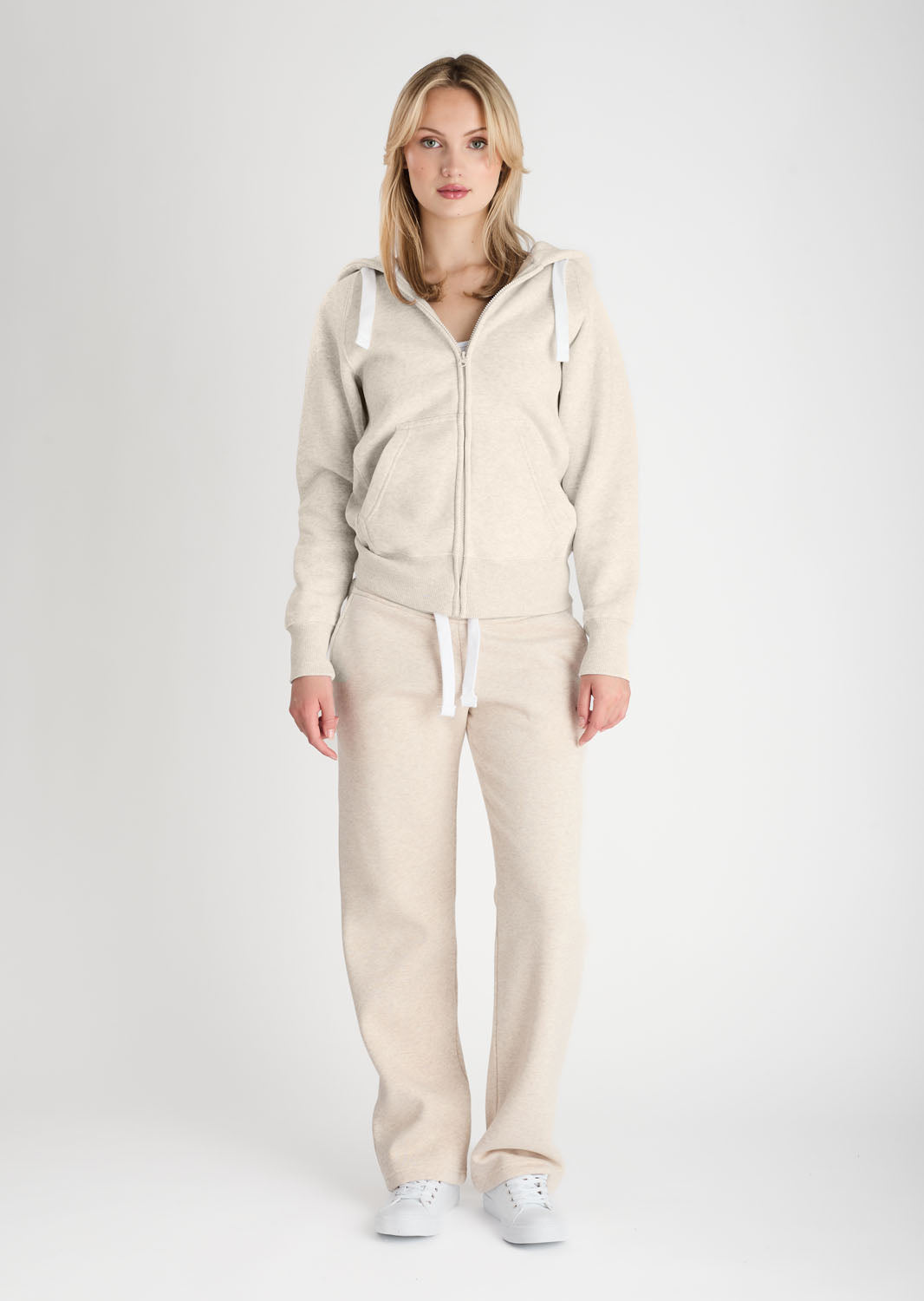 Woman wearing a beige tracksuit on a white background