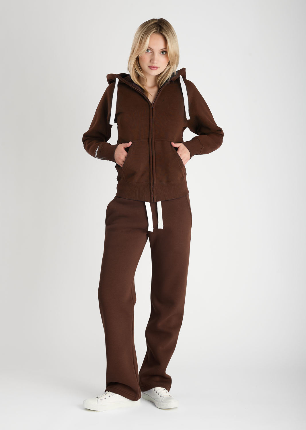 Woman wearing a brown tracksuit on a white background