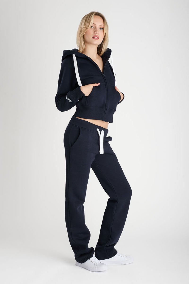 Woman wearing a navy tracksuit with white drawstrings on a white background