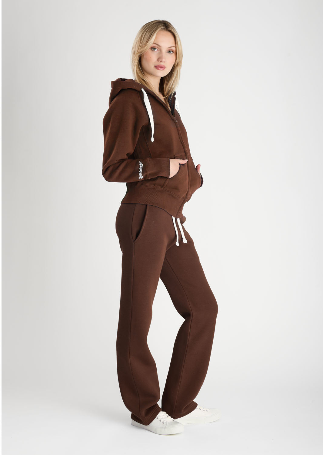 Woman wearing a brown tracksuit on a white background