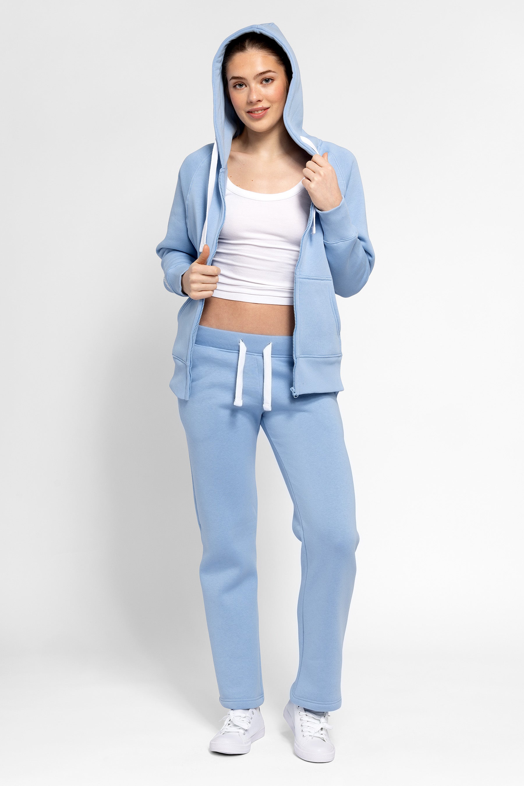 Woman wearing a light blue tracksuit on a white background